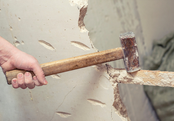 demolition work and rearrangement. worker with sledgehammer destroying wall